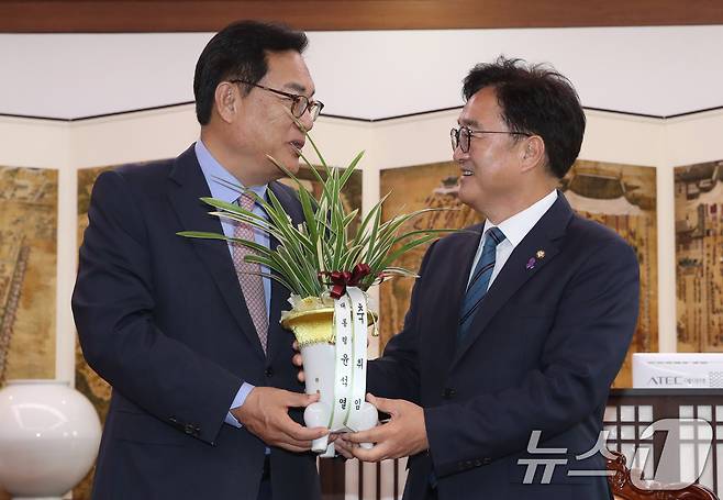 우원식 국회의장이 10일 오전 서울 여의도 국회를 찾은 정진석 대통령 비서실장으로 부터 윤석열 대통령이 보낸 취임 축하 난을 전달받고 있다. 2024.6.10/뉴스1 ⓒ News1 이광호 기자