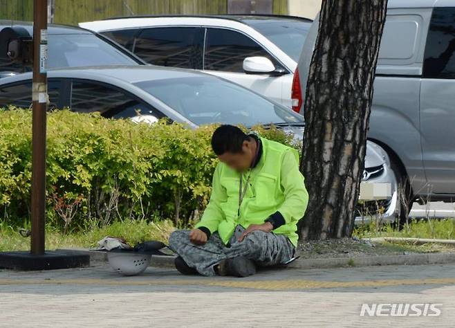 [청주=뉴시스] 조성현 기자 = 낮 최고기온이 30도에 이르며 더위가 이어진 10일 오후 충북 청주시 청원구 한 인도에서 근로자 한 명이 그늘막 아래에서 햇볕을 피하고 있다. 2024.06.10. jsh0128@newsis.com