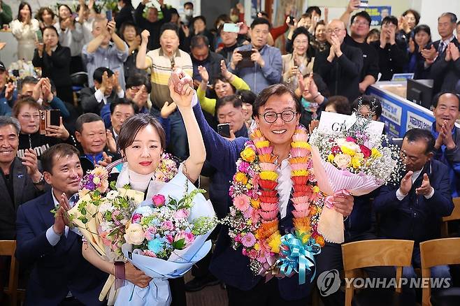 부산서 3선 민주당 의원 탄생 (부산=연합뉴스) 손형주 기자 = 제22대 국회의원선거일인 10일 오후 부산 북구갑 출마한 더불어민주당 전재수 후보가 당선이 유력하자 아내와 함께꽃다발을 들고 환호하고 있다.2024.4.11 handbrother@yna.co.kr