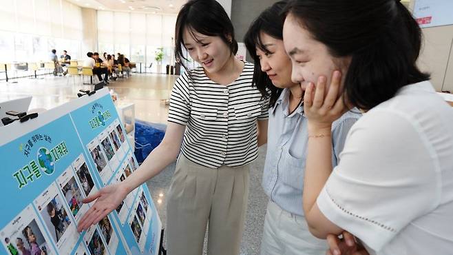 삼성전기 직원들이 11일 수원사업장에서 진행된 환경 작품 전시회를 감상하고 있다. 삼성전기 제공