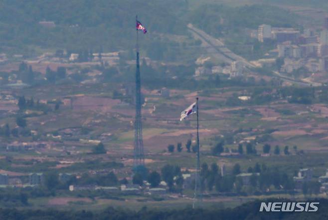 [파주=뉴시스] 정병혁 기자 = 국무회의에서 '9·19 남북군사합의' 전체 효력을 정지하는 방안을 심의했다. 한 총리는 "이러한 조치는 우리 법이 규정하는 절차에 따른 합법적인 것"이라며 효력 정지가 되면 "군사분계선 일대의 군사훈련이 가능해진다"고 말했다. 4일 경기 파주시 접경지역에서 바라본 남측 대성동 마을에 태극기와 북측 기정동에 인공기가 펄럭이고 있다. 2024.06.04. jhope@newsis.com