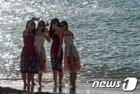 하와이 와이키키 해변에서 관광객들이 셀카를 찍고 있다. ⓒ AFP=뉴스1 ⓒ News1 김혜지기자