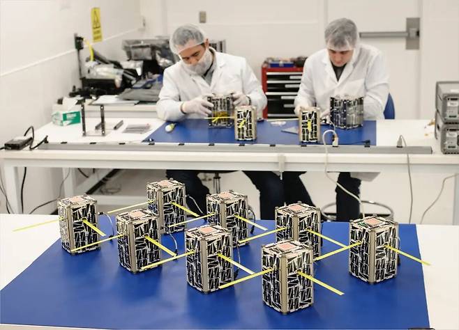 미 항공우주국(NASA) 연구원들이 클린룸에서 초소형위성을 제작하고 있다. 연구원들 앞으로 2U(유닛)짜리로 보이는 초소형위성 8기가 완성된 채 출고를 기다리고 있다. /NASA