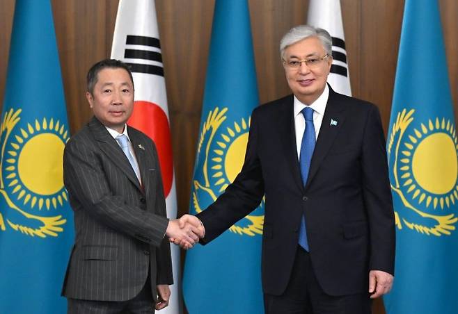 박정원 두산그룹 회장(왼쪽)이 카심 조마르트 토카예프 카자흐스탄 대통령과 면담에 앞서 악수를 나누고 있다. 두산에너빌리티 제공