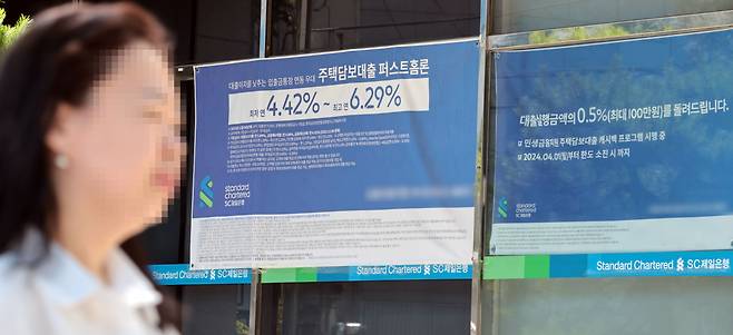 서울 한 시중은행 영업점의 대출 안내문 앞을 시민이 지나가고 있다.[연합]