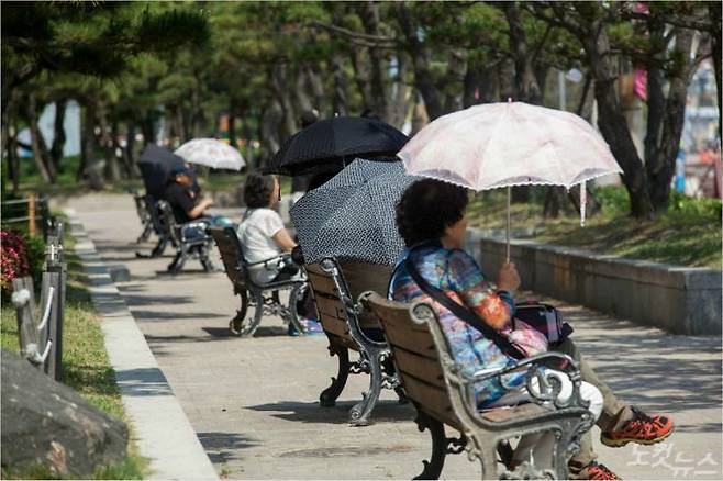 무더위에 양산을 쓰고 휴식하는 시민들. 송호재 기자