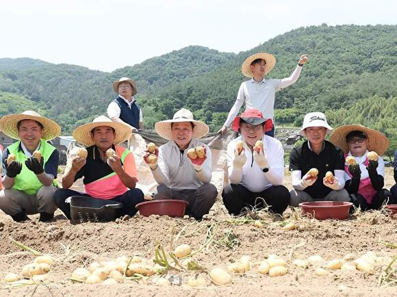 14일 박완수 경상남도지사(가운데)와 홍태용 김해시장(오른쪽 세 번째)을 비롯한 참석자들이 수확한 감자를 들어 보이고 있다. [사진=경상남도]