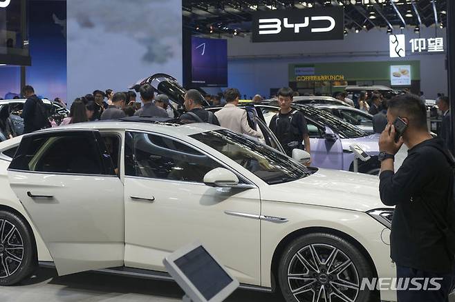 [베이징=AP/뉴시스]지난 4월26일 중국 베이징에서 열린 중국 오토쇼에서 관람객들이 비야디(BYD) 부스에서 자동차를 바라보고 있다. 유럽연합(EU)이 반보조금 조사에 이어 7월4일부터 중국산 전기자동차 수입에 최대 38%의 추가 관세를 부과하겠다고 12일 위협, 무역전쟁이 촉발될 위험이 있다고 AFP 통신이 보도했다. 2024.06.12.