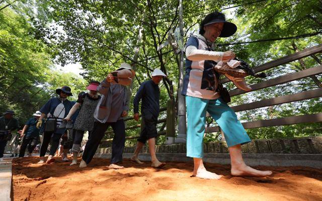 13일 서울 서대문독립공원 뒤 현저테니스장 인근에 조성된 천연동 황톳길에서 시민들이 맨발로 산책하고 있다. 뉴스1