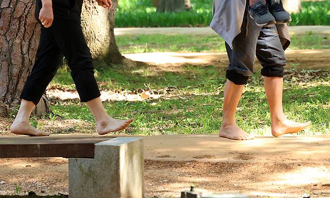 시민이 신발을 벗고 맨발로 산책하고 있다. 연합뉴스