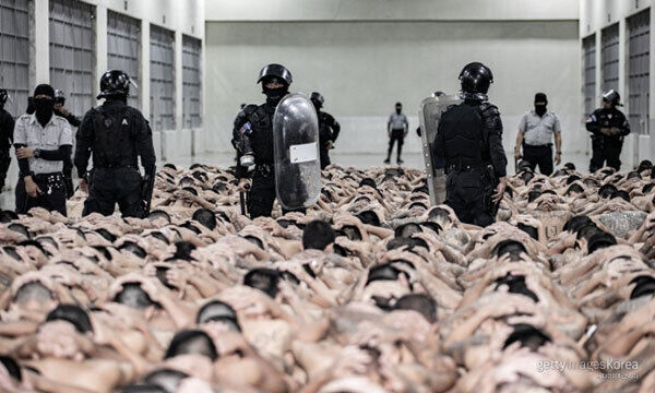 수감자들이 머리에 손깍지를 낀 채 테러범수용센터 바닥에 앉은 모습. 엘살바도르 대통령실 제공