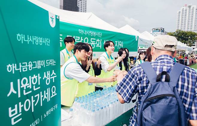 지난 15일 서울시 동작구 노량진축구장에서 열린 '농가족 명랑운동회'에 참여한 하나금융그룹 임직원들이 생수를 나눠주며 수어로 인사하고 있다. 사진=하나금융그룹 제공