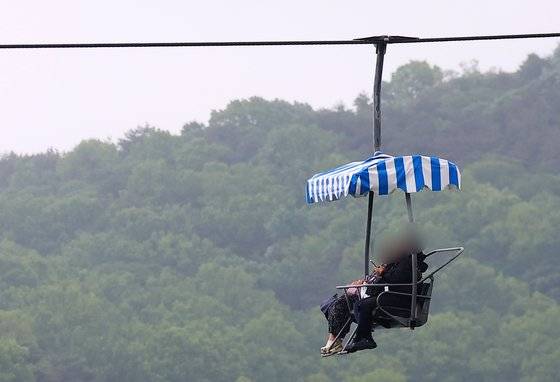 지난 6일 비가 내린 경기 과천시 서울대공원을 찾은 시민들이 리프트를 타고 이동하고 있다. 연합뉴스