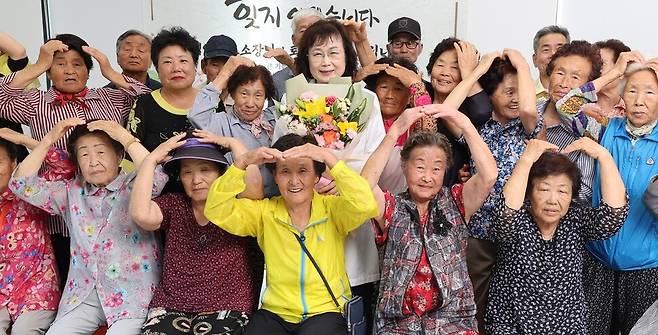 김영 산음보건진료소장(가운데 꽃 든 이)이 지난 12일 경기 양평군 단월면 산음리 마을회관에서 열린 퇴임 환송식에서 마을 주민들과 함께 기념촬영을 하고 있다. 박종식 기자 anaki@hani.co.kr