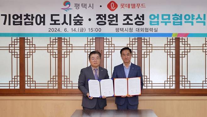 지난 14일 박경섭 롯데웰푸드 생산본부장(사진 왼쪽)과 정장선 평택시장이 도시숲·정원 조성 업무협약을 체결하고 기념촬영을 하고 있다./사진=롯데웰푸드