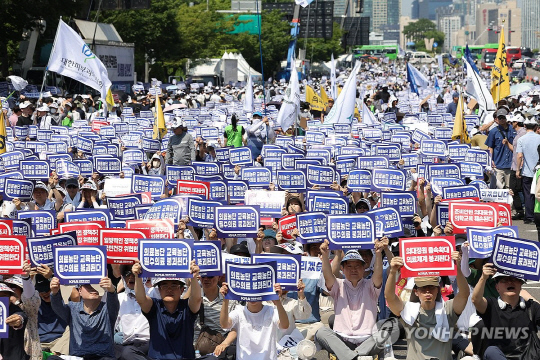 대한의사협회(의협)의 주도로 개원의와 일부 의대 교수들이 집단휴진에 나선 18일 오후 서울 영등포구 여의대로에서 열린 전국 의사 총궐기대회에서 참가자들이 팻말을 들고 있다.<사진: 연합뉴스>