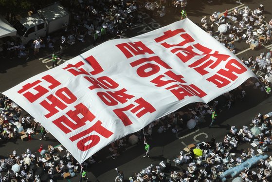 18일 오후 서울 영등포구 여의대로에서 열린 전국 의사 총궐기대회에서 의사들이 '의료농단' 등 문구가 적힌 대형현수막을 펼치고 있다. 연합뉴스