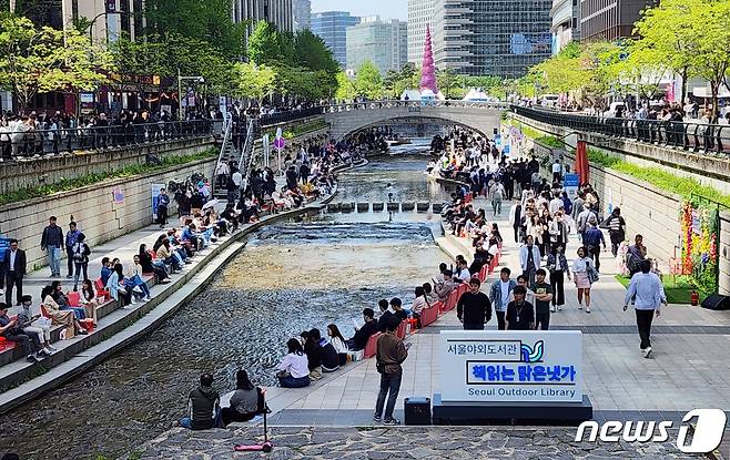 서울야외도서관 운영 첫 날인 18일 서울 종로구 청계천 마련된 '책 읽는 맑은냇가'를 찾은 시민들이 독서를 즐기고 있다. 2024.4.18/뉴스1 ⓒ News1 박세연 기자