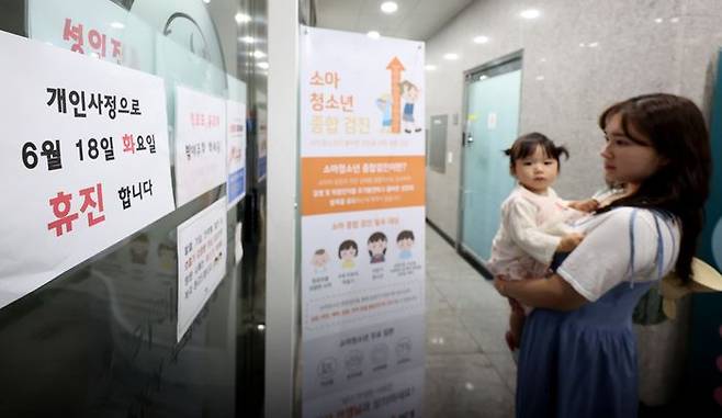 대한의사협회가 의대 증원 등 의료개혁을 규탄하는 집단 휴진에 나선 18일 대구 시내의 한 소아청소년과를 찾은 엄마와 아이가 휴진 안내문을 바라보고 있다. ⓒ뉴시스