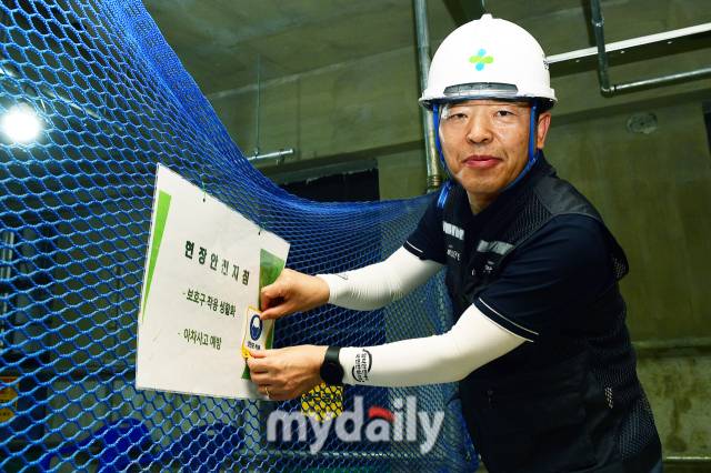 고광재 안전보건공단 서울광역본부장이 안전모 착용 문구가 적힌 스티커를 공사현장에 붙이고 있다. /사진 = 곽경훈 기자