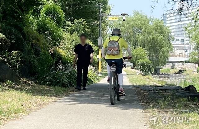 19일 수원특례시 권선구 세류동 수원천 산책로의 자전거·보행자 겸용도로에서 보행자 옆으로 자전거가 지나가고 있다. 오종민기자