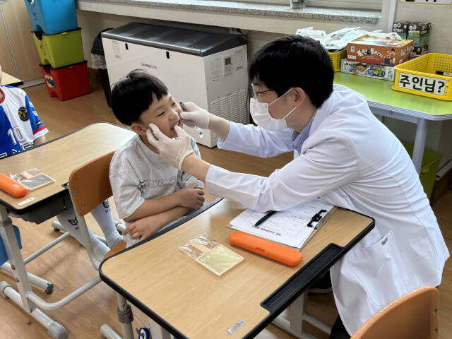 경기도치과의사회 소속 의사가 20일 양주시 상수초등학교 학생에게 의료봉사를 하고 있다. 경기도치과의사회 제공