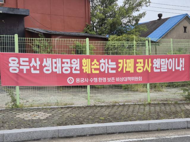 ▲공사장 인근 도로에 '용두산 생태공원 훼손하는 카페 공사 왠말이냐!'라는 플래카드를 게시해 놓은 모습.ⓒ프레시안(임성현)