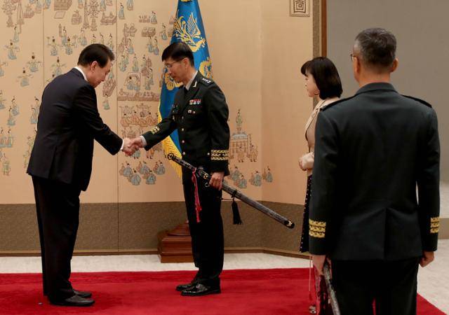 윤석열 대통령이 지난해 11월 서울 용산 대통령실 청사에서 열린 중장 진급 보직 신고 및 삼정검 수치 수여식에서 국방부 직할기관인 국방대학교 총장 임기훈에게 수치수여를 하고 있다. 서재훈 기자