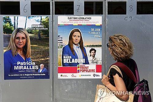 한 프랑스 시민이 남부 프랑스의 거리에 붙은 선거 포스터를 살펴보고 있다.  [EPA 연합뉴스 자료사진. 재판매 및 DB 금지]