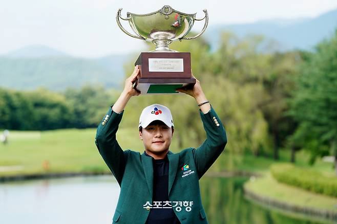 김민규가 23일 충안 천안 우정힐스CC에서 열린 제66회 한국오픈 골프선수권대회 최종라운드에서 3타차 우승을 거둔 뒤 트로피를 번쩍 치켜들고 기념촬영 하고 있다. ｜코오롱 한국오픈 대회조직위원회 제공