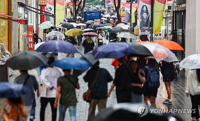 비 내리는 서울 (서울=연합뉴스) 서대연 기자 = 비가 내린 22일 오전 서울 명동거리에 시민들과 관광객들이 우산을 쓰고 이동하고 있다, 2024.6.22 dwise@yna.co.kr