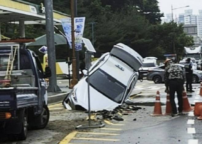 평택 한 도로에서 상수도관 파열로 생긴 싱크홀에 빠진 택시(사진=연합뉴스)