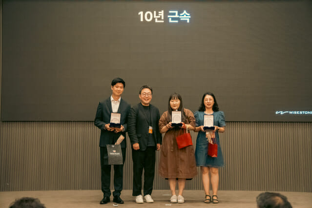 와이즈스톤은 21일 강남 더 리버사이드 몽블랑홀에서 ‘창립 17년 기념행사’를 개최했다. 이영석 대표(왼쪽 두번째)가 10주년 근속 직원들에게 상패와 부상을 주고 기념사진을 찍었다.