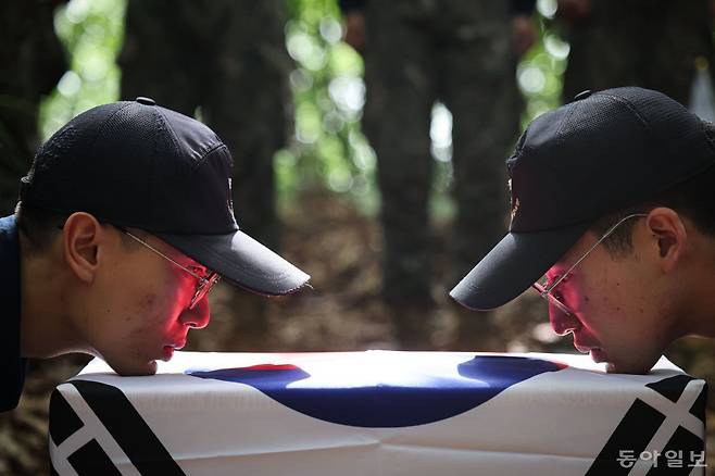 유해발굴감식단 장병들이 전사자 유해가 담기는 오동나무 관에 태극기를 감싼 뒤 얼굴을 가까이 붙여 틀어진 부분과 주름이 있는지 확인하고 있다. 파주=박형기 기자 oneshot@donga.com