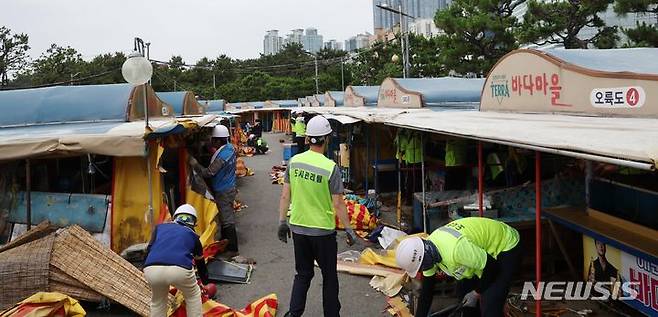 [부산=뉴시스] 하경민 기자 = 1960년대 초부터 영업을 한 부산 해운대 바다마을 포장마차촌이 추억 속으로 사라졌다.  25일 해운대구청 관계자들이 중장비를 동원해 포장마차촌을 철거하고 있다.  이 포장마차촌은 시유지 무단점용과 무신고 영업행위 등 논란이 끊이지 않았고, 해운대구는 2021년 상인들과 2년6개월의 유예기간을 거쳐 올 1월31일 자진 철거하기로 합의하고 이날 최종 철거에 나섰다. 2024.06.25. yulnetphoto@newsis.com