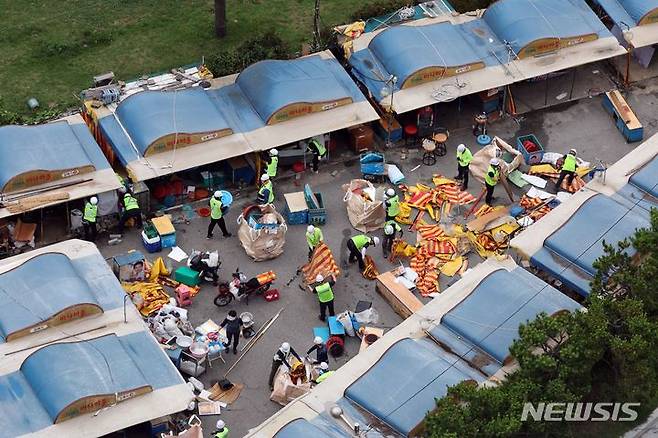 [부산=뉴시스] 하경민 기자 = 1960년대 초부터 영업을 한 부산 해운대 바다마을 포장마차촌이 추억 속으로 사라졌다.  25일 해운대구청 관계자들이 중장비를 동원해 포장마차촌을 철거하고 있다.  이 포장마차촌은 시유지 무단점용과 무신고 영업행위 등 논란이 끊이지 않았고, 해운대구는 2021년 상인들과 2년6개월의 유예기간을 거쳐 올 1월31일 자진 철거하기로 합의하고 이날 최종 철거에 나섰다. 2024.06.25. yulnetphoto@newsis.com