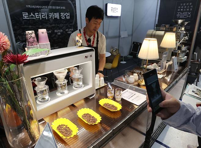 지난 13일 서울 강남구 세텍에서 열린 '제22회 제일 창업박람회 & 카페창업쇼'의 한 부스에서 커피 머신을 설명하고 있다. /연합뉴스