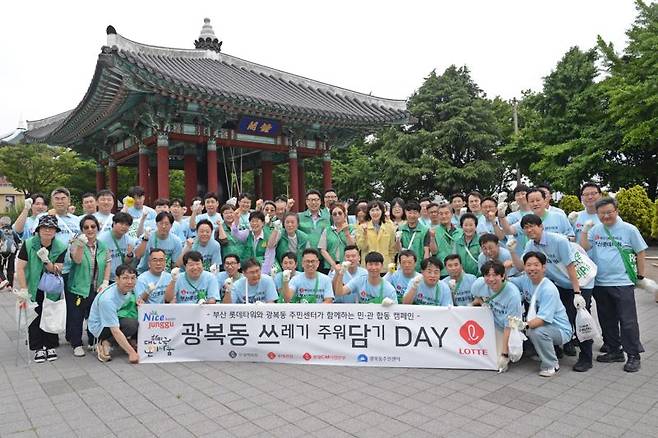 부산롯데타워TF팀이 지난 25일 광복동 주민센터, 광복동 새마을단체 등과 함께 부산 중구 광복동 일대에서 환경정화 활동을 펼친 후 단체 기념촬영을 하고 있다. 롯데백화점 제공