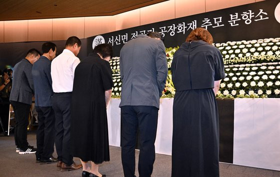 26일 경기 화성시청 로비에 마련된 아리셀 공장 화재 사고 희생자 추모 합동분향소에서 추모객들이 묵념을 하고 있다. 뉴스1