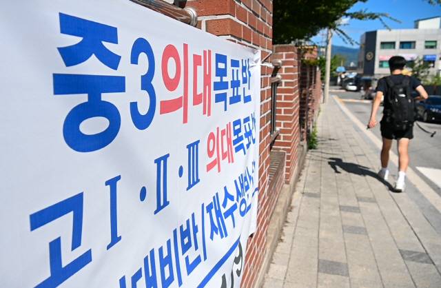 ▲ 의과대학 증원이 확정되면서 ‘지방유학’ 현상을 예측하는 전망이 나오는 가운데 25일 춘천고등학교 정문에 여름방학 동안 의대 입시반을 운영한다는 내용의 학원 홍보 펼침막이 붙어 있다.  유희태