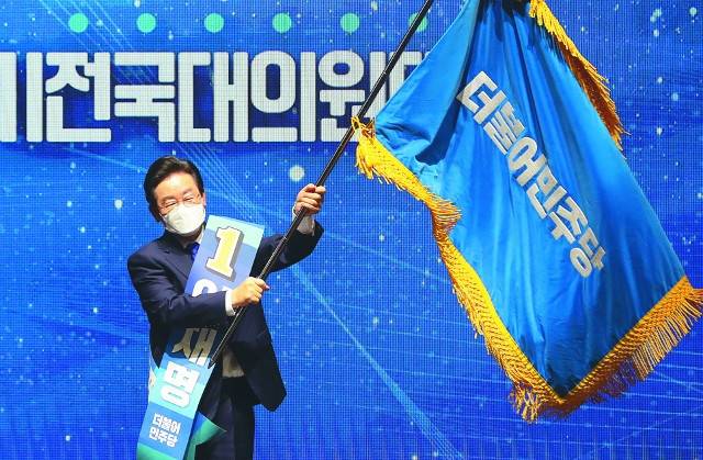 이재명 더불어민주당 대표가 2년 전인 2022년 8월 28일 서울 송파구 올림픽 체조경기장에서 열린 정기전국대의원대회에서 새 당대표로 선출된 뒤 당기를 흔들고 있다. 이 대표는 오는 8월 있을 전당대회에도 출마해 연임할 것이라는 관측이 지배적이다. 이한형 기자