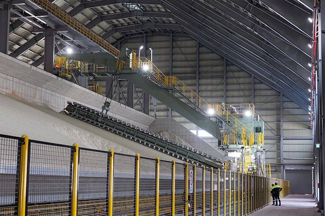 포스코필바라리튬솔루션 직원들이 원료 창고에 적재된 호주산 리튬광석 원료를 살펴보고 있다.  포스코홀딩스