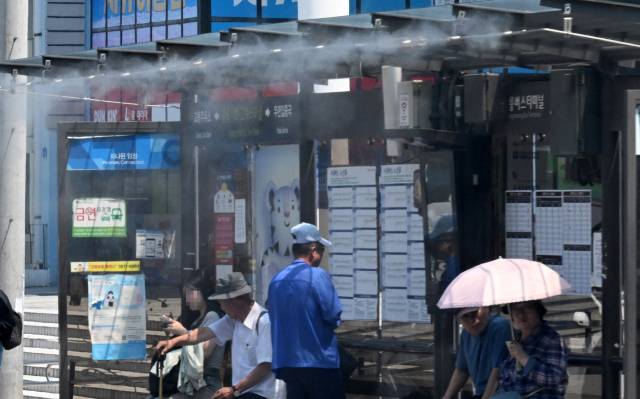한낮 최고기온이 연일 30도를 훨씬 넘는 불볕더위가 이어진 18일 강원 강릉시 한 시내버스 승강장에 안개형 냉방장치(쿨링포그)가 가동되고 있다. 연합뉴스