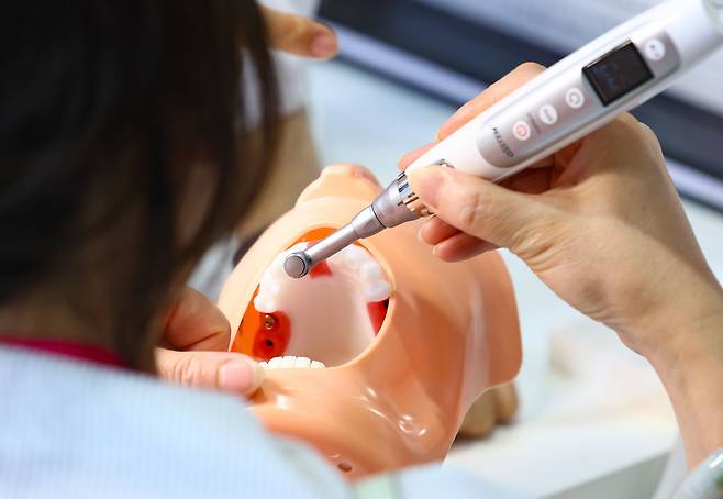 7일 오후 서울 강남구 코엑스에서 개막한 서울국제치과기자재전을 찾은 관람객들이 임플란트 시술 기기를 체험하고 있다. /뉴시스