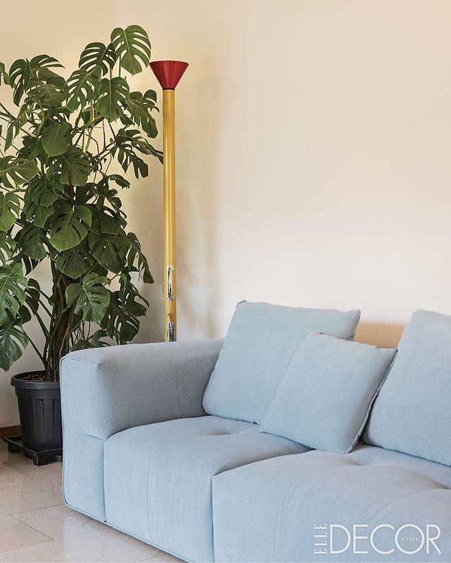 알로소의 하늘색 소파와 아르떼미데의 칼리마코 스탠드 조명이 어우러져 있다.