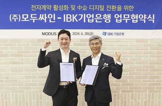 임문택 IBK기업은행 기업고객그룹 부행장(오른쪽)과 이영준 모두싸인 대표가 28일 서울 중구 IBK파이낸스타워에서 열린 업무협약식에서 기념촬영을 하고 있다. IBK기업은행 제공