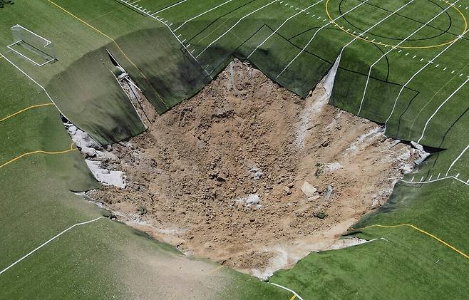 27일(현지시각) 미국 일리노이주 알톤 공원 잔디 축구장에 생긴 싱크홀. 로이터 연합뉴스
