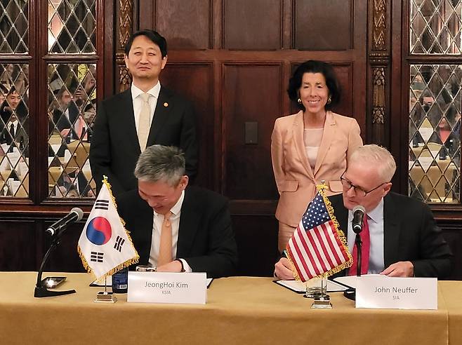 한미 공급망·산업 대화(SCCD) 반도체 포럼 (워싱턴=연합뉴스) 김동현 특파원 = 한국반도체산업협회 김정회 상근부회장과 존 뉴퍼 미국반도체산업협회 회장이 27일(현지시간) 워싱턴DC의 한 호텔에서 열린 '한미 공급망·산업 대화(SCCD) 반도체 포럼'에서 반도체 공급망 협력을 위한 양해각서(MOU)를 체결하고 있다. 안덕근 산업통상자원부 장관과 지나 러몬도 미국 상무부 장관이 서명식을 지켜보고 있다. 2024.6.27