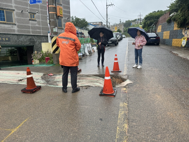 29일 오후 2시36분쯤 전남 여수시 미평동에서 장마로 인해 도로가 무너져 소방당국이 복구 작업을 하고 있다./뉴스1=전남연수소방소제공