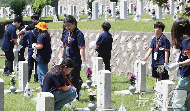 28일 오전 서울 동작구 국립서울현충원에서 열린 ‘나라사랑 리더십새싹 캠프’에서 어린이들이 묘비를 닦고 있다. 2024.6.28/뉴스1 ⓒ News1 임세영 기자